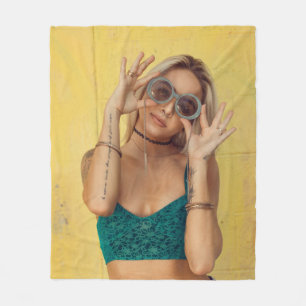 Woman in blue bralette holding sunglasses putting fleece blanket