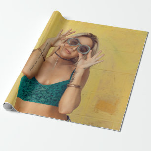 Woman in blue bralette holding sunglasses putting  wrapping paper