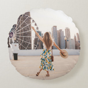 Woman in white and blue floral dress holding hat round pillow
