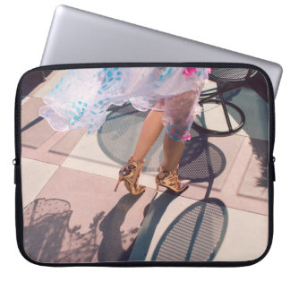 Woman in white pink and green floral skirt and bro laptop sleeve