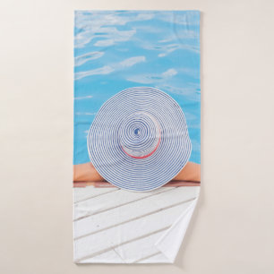 Woman leaning on white concrete surface beside swi bath towel