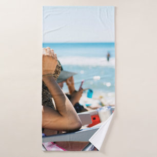 Woman lying on sun lounger covering her face with  bath towel