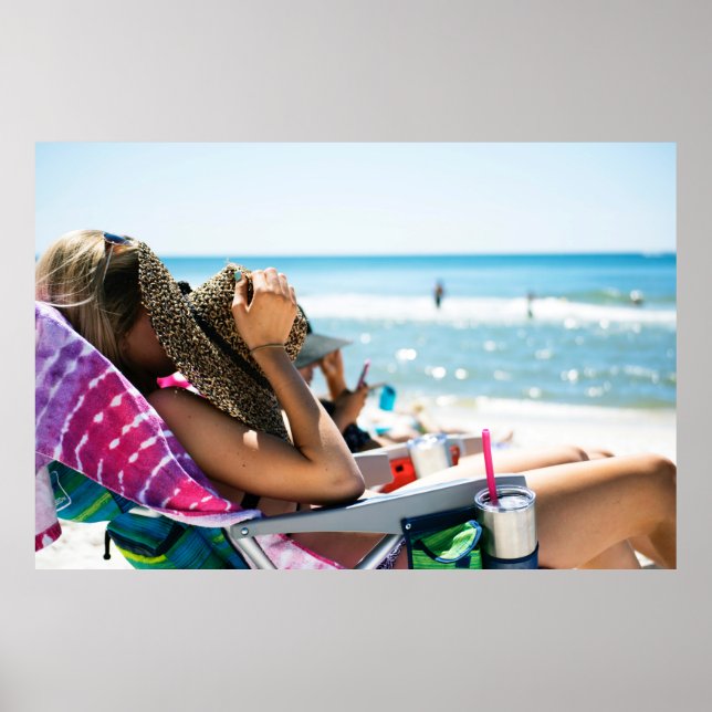 Woman lying on sun lounger covering her face with  poster (Front)
