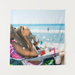 Woman lying on sun lounger covering her face with tapestry