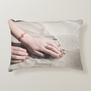 Woman lying on white sand accent pillow