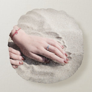 Woman lying on white sand round pillow