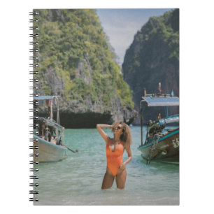 Woman on body of water between brown boats notebook