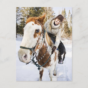 Woman on horse outdoors during winter postcard