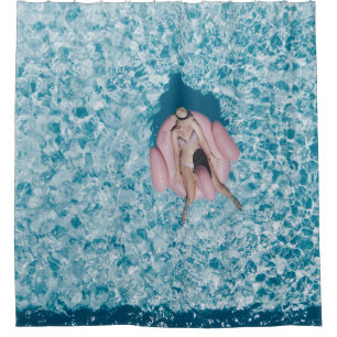 Woman on pink buoy surrounded by body of water in