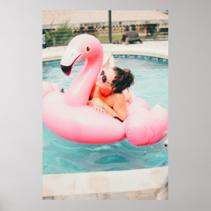 Woman on pink inflatable flamingo on outdoor pool poster