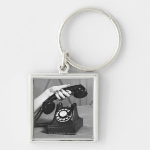 Woman picking up phone close up of hand keychain