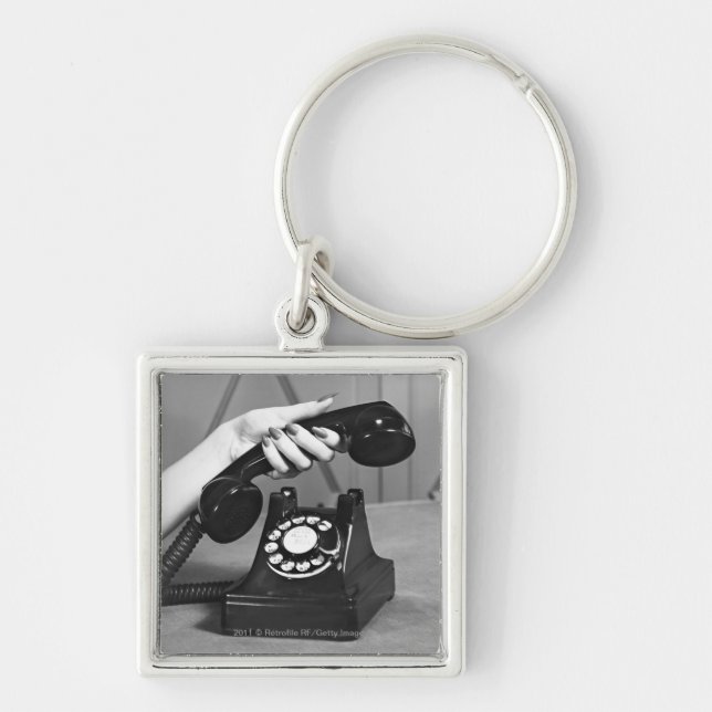 Woman picking up phone close up of hand keychain (Front)