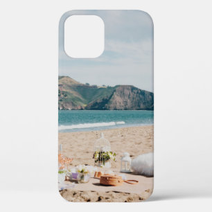 Woman sitting near seashore while looking at Golde iPhone 12 Case