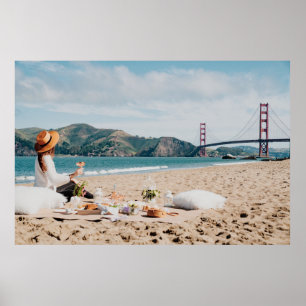 Woman sitting near seashore while looking at Golde Poster