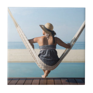 Woman Sitting On A Hammock At A Small Hotel Tile