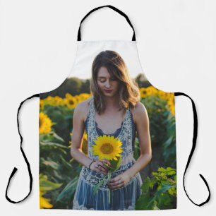 Woman standing at sunflower field apron