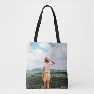 Woman standing near trees tote bag