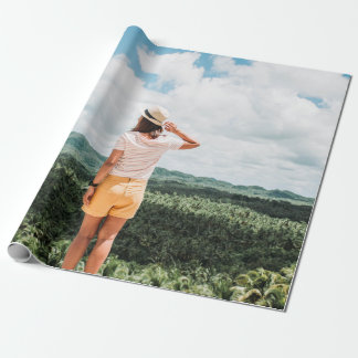 Woman standing near trees wrapping paper