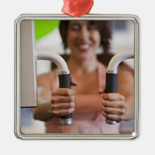 Woman using exercise machine in gym metal ornament