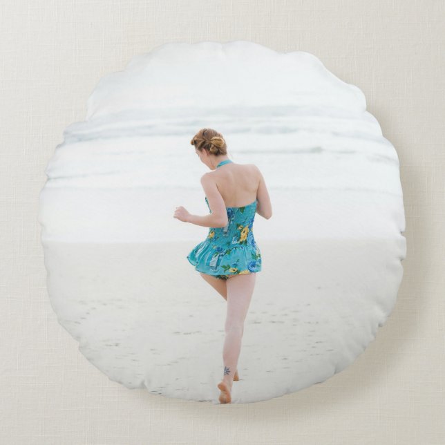 Woman walking on shore near beach round pillow (Front)