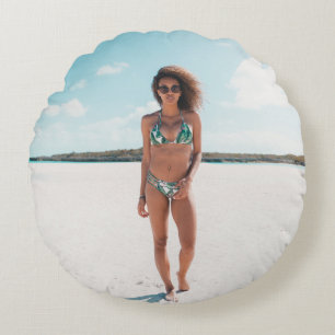 Woman wearing bikini standing on sand round pillow