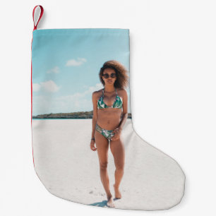 Woman wearing bikini standing on sand small christmas stocking