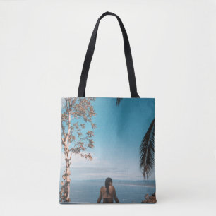 Woman wearing black bikini tap swimming on body of tote bag