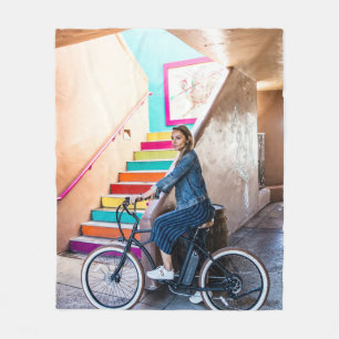 Woman wearing blue denim jacket and shorts riding fleece blanket