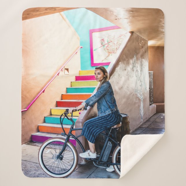 Woman wearing blue denim jacket and shorts riding  sherpa blanket (Front)