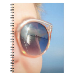 Woman wearing brown framed sunglasses notebook