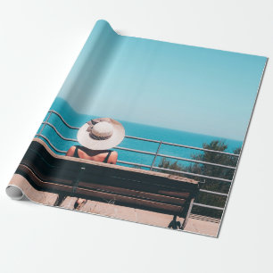 Woman wearing white straw hat sitting on bench loo wrapping paper