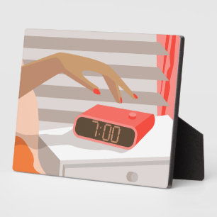Womans hand pushing on alarm clock snooze button plaque