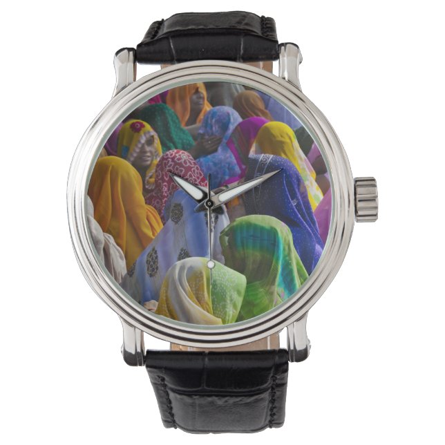 Women in colourful saris gather together watch (Front)