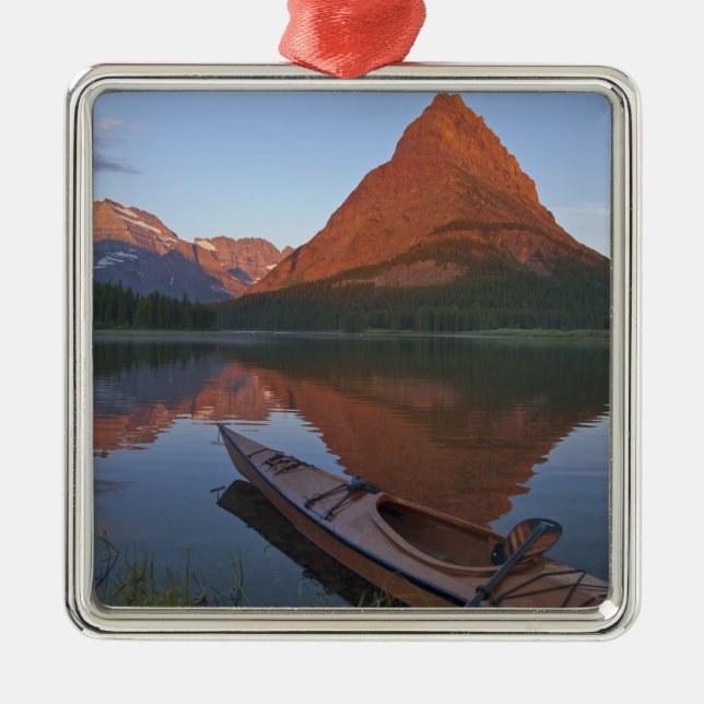Wooden kayak in Swiftcurrent Lake at sunrise in Metal Ornament (Front)
