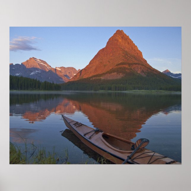 Wooden kayak in Swiftcurrent Lake at sunrise in Poster (Front)