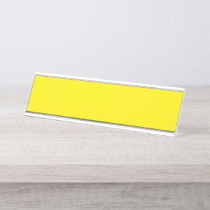 Yellow and orange abstract shapes overlap on a pla desk name plate