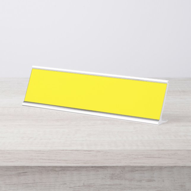Yellow and orange abstract shapes overlap on a pla desk name plate (Front)