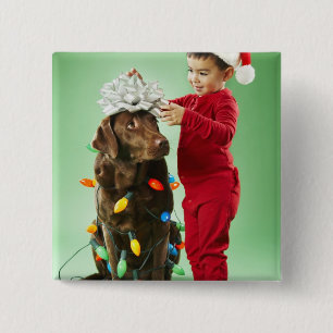 Young boy wrapping Christmas lights around a dog 2 Inch Square Button