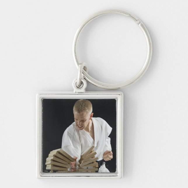 Young man breaking boards with karate chop on keychain (Front)