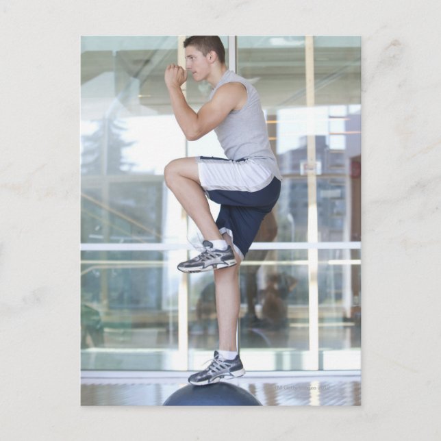 young man doing step-up exercises on a balance postcard (Front)