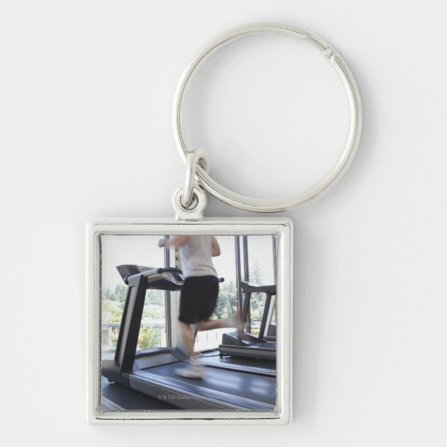 Young man running on a treadmill at health club, keychain (Front)