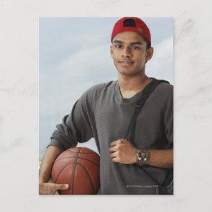 young man with red cap holding basket ball and postcard