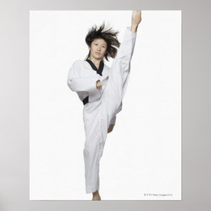 Young woman practicing kicking poster