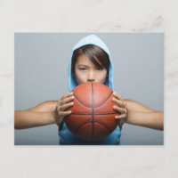 Young woman with basketball looking at camera